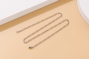 Macro detail of silver Figaro chain necklace and bracelet with interlocking steel links