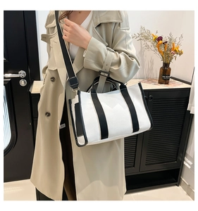 Detail of minimalist black and white canvas tote bag with adjustable shoulder strap