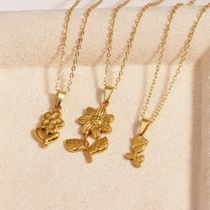 Detailed view of three 18K gold plated necklaces with sunflower and rose flower pendants