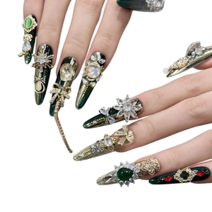 Unghie stiletto fatte a mano con lussuosi strass color smeraldo e ciondoli in metallo oro
