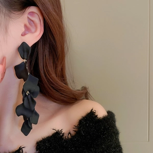 Detail shot of long black floral petal tassel earrings featuring layered matte petals