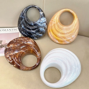 Detail view of four marble patterned acrylic evening clutches in varied colors