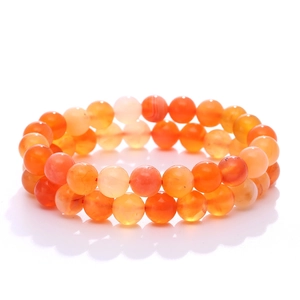 Natural orange carnelian bead bracelets set with smooth round gemstone texture on white background
