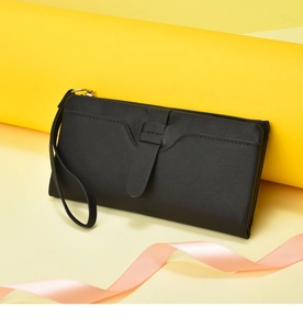 Black long wallet detail view showing fine texture, wrist strap and secure closure.