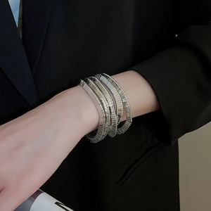 Detail of silver multi-layered metallic bracelet featuring fine textured horizontal stripes