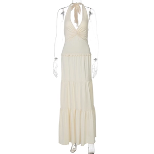 Detail of elegant V-neck halter dress with layered ruffle hem and twist knot design in beige