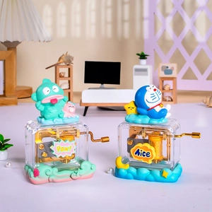 Handkurbel-Spieluhr aus transparentem Harz mit Doraemon und Hangyodon Figuren