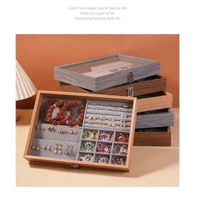 Detail of stacked walnut wood jewelry boxes with gray velvet lining for rings and necklaces
