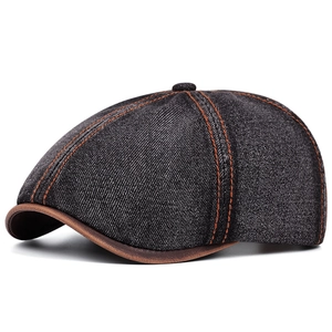 Vintage black denim newsboy cap with orange stitching and brown leather brim accents