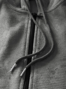 Close-up of grey hoodie featuring metallic drawstring tips and high-quality knit texture