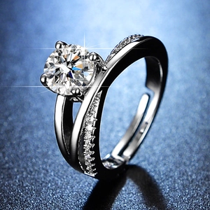 Macro shot of a classic six-prong moissanite ring with a diamond-set crossover band