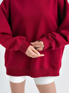 Λεπτομέρεια από μπορντό oversized φούτερ με ριμπ ύφανση στις μανσέτες και στο στρίφωμα