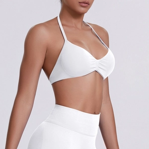 Detail of white high-elastic ribbed sports bra with halter neck straps on a model
