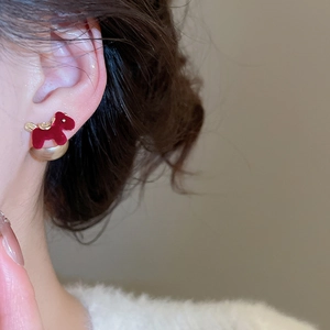 Detail of red flocked puppy earring with gold pearl butterfly back on ear model