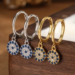 Detail view of gold and silver S925 sterling silver evil eye hoop earrings with blue zircon