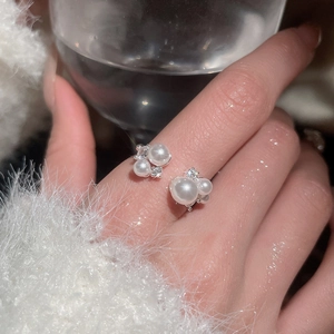 Close-up of elegant silver open ring featuring lustrous pearls and sparkling zircons