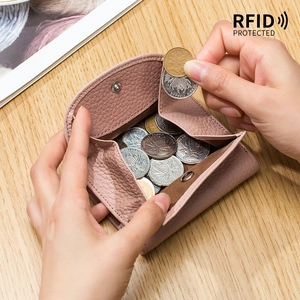 Mini portafoglio rosa in pelle con protezione RFID aperto su un tavolo di legno