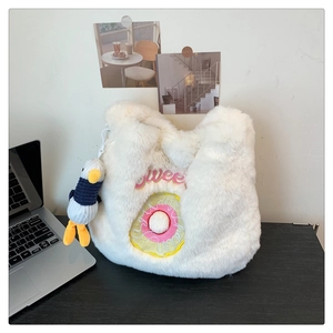 Close-up of white plush bag with 'Sweet' donut embroidery and penguin charm detail