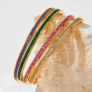 Gold stainless steel bangle set featuring colorful rectangular zircons on textured stone