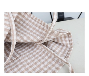 Detail of beige and white checkered canvas tote bag with reinforced stitching