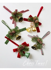 Detail of Christmas ornaments with pine cones, bows, and bells in festive red and green