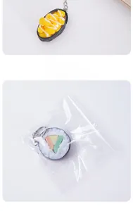 Close-up of artificial sushi keychain with corn and salmon rolls in clear packaging