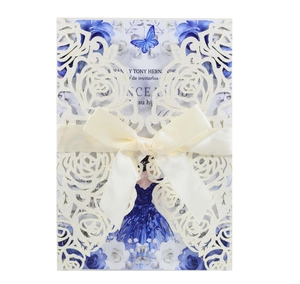 Detail of laser-cut rose invitation with beige ribbon bow and blue butterfly insert