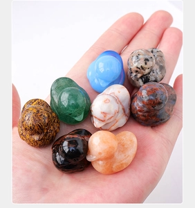 Close-up of eight diverse natural crystal ducks held in palm showing varied textures