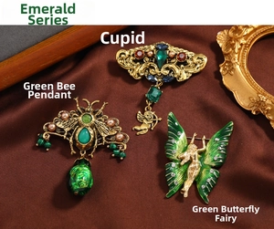 Macro detail of emerald-toned butterfly and bee brooches with vintage gold accents