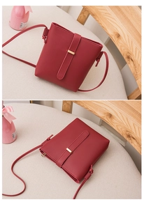 Detailed close-up of wine red faux leather bucket bag with decorative strap and fine texture