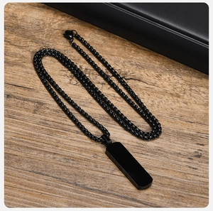 Rectangle black stainless steel pendant necklace shown on a textured wooden background