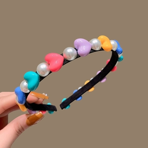 Fashionable headband with colorful heart beads and white pearls on a slim black band