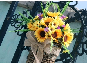 Dettaglio di cesto di girasoli appeso con fiocco di tela rustica su cesto di vimini