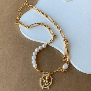 Macro detail of tulip pendant necklace with natural pearls and elegant gold-plated finish
