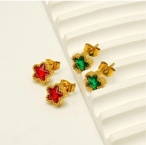 Macro shot of gold stainless steel star earrings with red and green cubic zirconia inlay