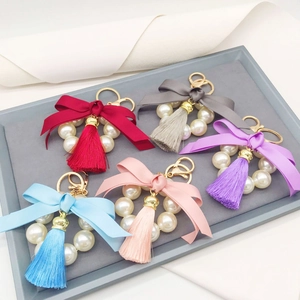 Detail of colorful pearl tassel bow keychains in red, grey, purple, blue, and pink colors