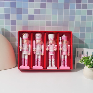 Detailed view of four pink wooden nutcracker soldiers in a red gift box packaging
