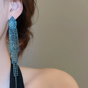 Close-up of long blue crystal tassel earrings showing flowing rhinestone chains