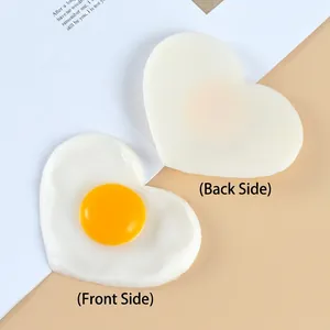 Heart-shaped fried egg keychain ornament made of PVC, showing both sides on a white card