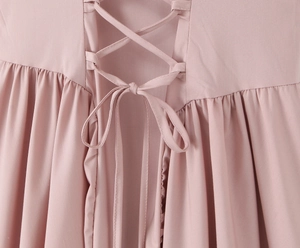 Détail de robe rose avec laçage au dos et design élégant plissé à la taille du vêtement