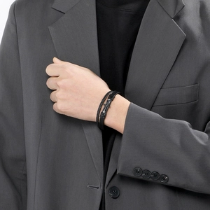 Detail of men's layered leather bracelet featuring an Ankh cross charm and magnetic clasp