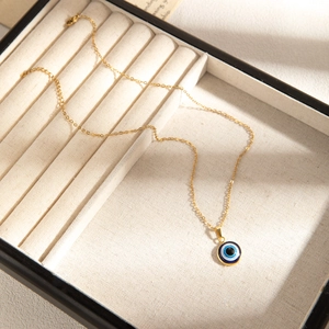 Detail of evil eye necklace with blue enamel pendant in a luxury jewelry gift box
