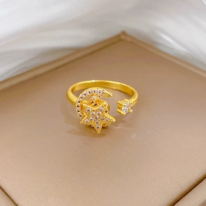 Detailed close-up of a rotating gold star and moon adjustable ring on a leather tray