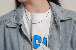 Close-up of minimalist black snake chain necklace on model with 18k plating