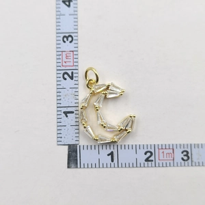 Detailed size measurement of a gold crescent moon pendant with rectangular clear gems
