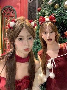 Detail of Christmas headband with reindeer antlers and festive red bow on a model