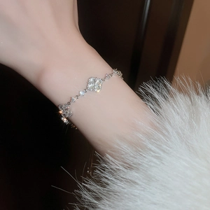 Close-up of silver four-leaf clover bracelet with white mother of pearl and tiny diamonds
