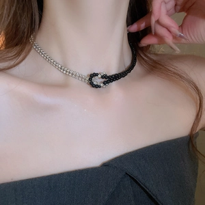 Dettaglio della collana stile Y2K con strass argento e perline nere con design a nodo