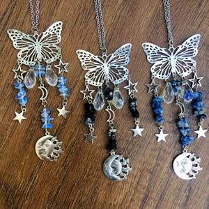 Detailed view of silver butterfly suncatchers with moon pendants and colorful crystals