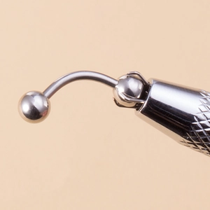Macro detail of stainless steel body piercing tool with knurled non-slip handle grip
